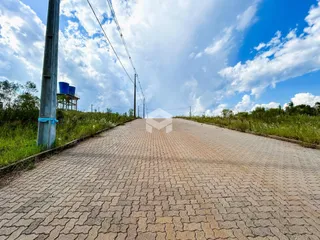 Uma estrada pavimentada se estende sob um céu azul e nublado.