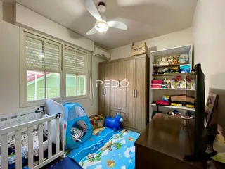 Foto interna de um quarto com móveis e janela em uma propriedade.