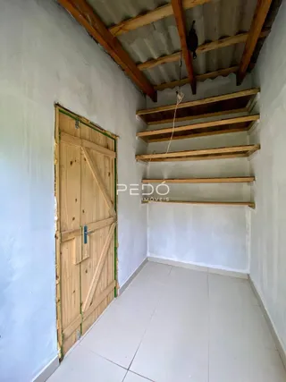 Interior com teto de madeira aparente e porta de madeira na parede.