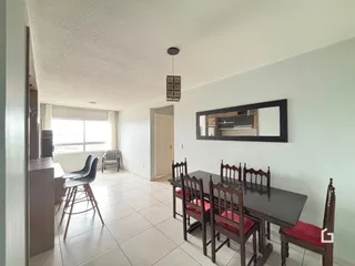 Interior de uma sala com mesa de jantar e piso de cerâmica clara.