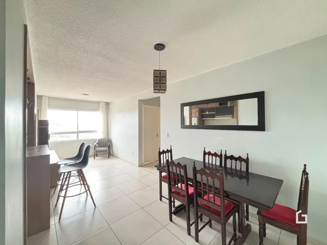 Interior de uma sala com mesa de jantar e piso de cerâmica clara.