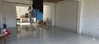 Interior de uma sala com paredes brancas e piso de cerâmica polida.