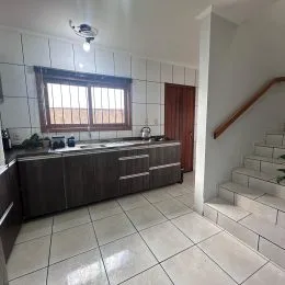 Foto de uma cozinha com armários e piso de cerâmica.
