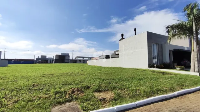 Vista externa de uma residência moderna com jardim verde.