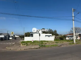 Vista externa de uma edificação branca em uma rua residencial.