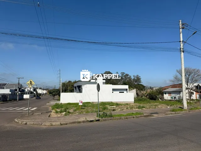 Vista externa de uma edificação branca em uma rua residencial.