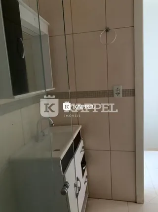 Foto de uma área de cozinha com armários brancos e revestimento de azulejos.
