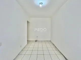 Corredor com paredes brancas e piso de cerâmica.