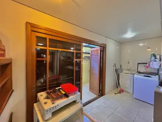 Interior de uma sala com porta de madeira e um armário de vidro.