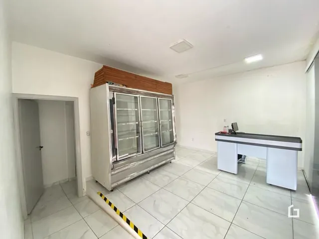 Ambiente interno com paredes brancas e piso de cerâmica clara.