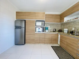 Foto de uma cozinha com armários de madeira e piso branco.