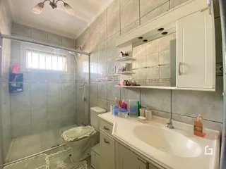 Foto de um banheiro com revestimento de cerâmica e bancada branca.