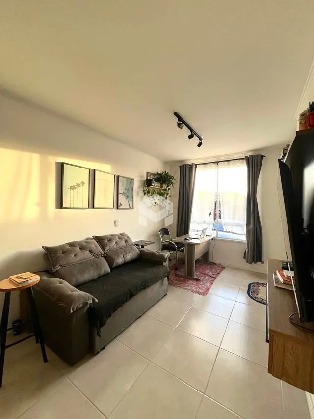 Sala de estar com sofá e grandes janelas.