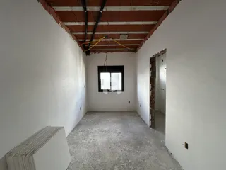 Vista de um corredor interno com teto de tijolos expostos.
