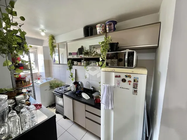 Vista interna de uma cozinha com armários e eletrodomésticos.