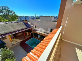 Vista da fachada de uma residência com piscina e parede de telha laranja.