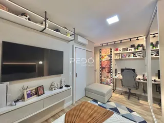 Foto de uma sala de estar com televisão e estantes em um imóvel no Brasil.