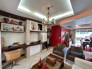 Sala de estar com decoração de madeira e parede vermelha em Lajeado.