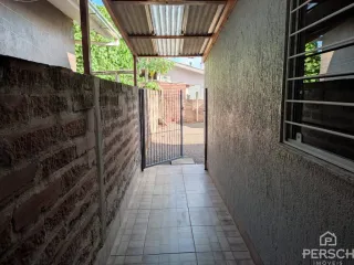 Foto de um corredor interno com paredes texturizadas e piso de cerâmica.