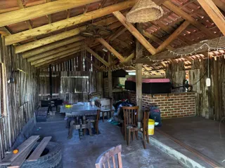 Interior rústico com vigas de madeira expostas e mesa de jantar.