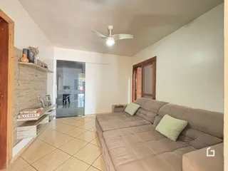 A sala de estar apresenta um sofá e piso de cerâmica.