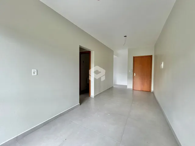 Corredor interno de uma residência com paredes brancas e piso cinza claro.