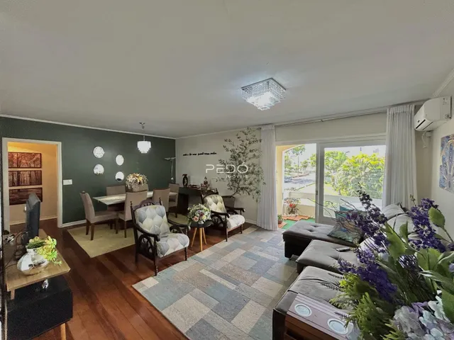 Sala de estar e jantar com piso de madeira e móveis de madeira escura.
