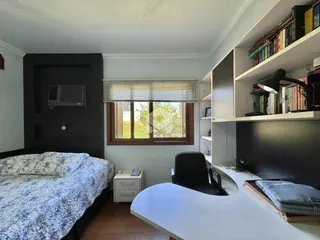Quarto com janela e estante de livros em um imóvel no Brasil.