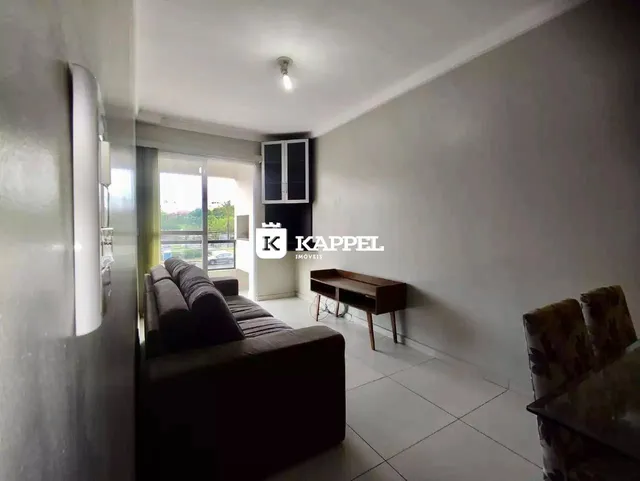 Sala de estar com sofá escuro e porta de vidro.