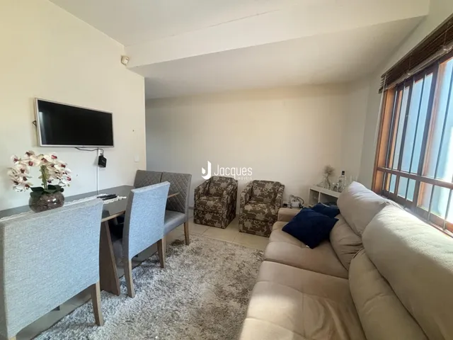 Sala de estar com sofá e mesa de jantar em um apartamento no Brasil.