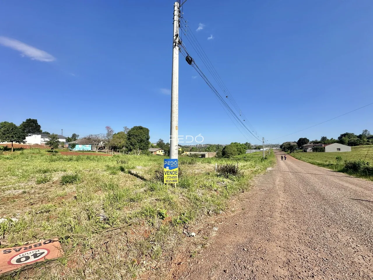 Paisagem rural com estrada de terra e poste de luz em Lajeado.