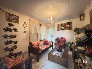 Sala de estar com decoração de madeira e cortinas claras.