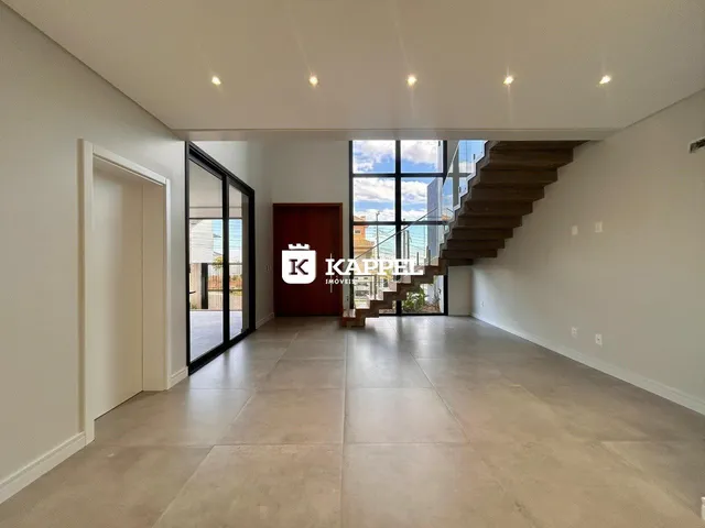 Ambiente interno com piso de porcelanato e escadaria em um apartamento.