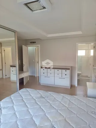 Quarto com cama de casal e espelho refletindo o ambiente.