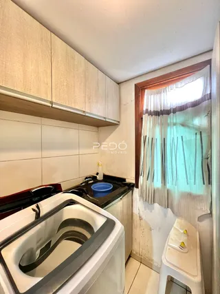 Vista de uma pia de cozinha com armários brancos em um imóvel no Brasil.
