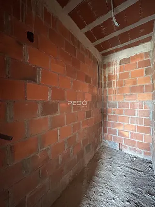 Parede interna com alvenaria de tijolos aparentes em uma construção.