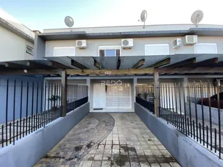 Vista da fachada de uma residência em Lajeado, Brasil, com um pátio pavimentado e cerca.