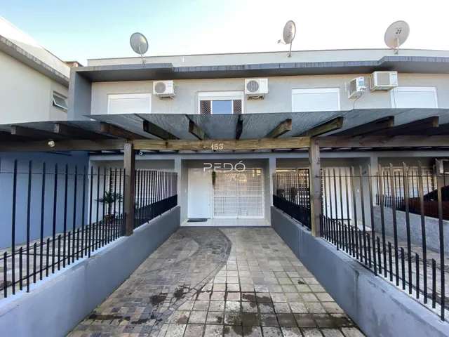 Vista da fachada de uma residência em Lajeado, Brasil, com um pátio pavimentado e cerca.