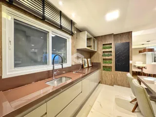 Cozinha moderna com bancada e armários brancos em um imóvel no Brasil.