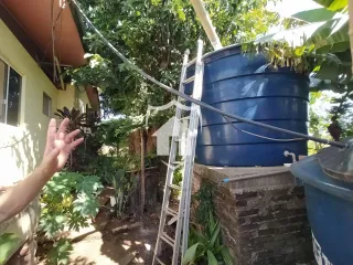 Fachada da propriedade em Lajeado, Brasil, mostrando um tanque azul e vegetação ao ar livre.