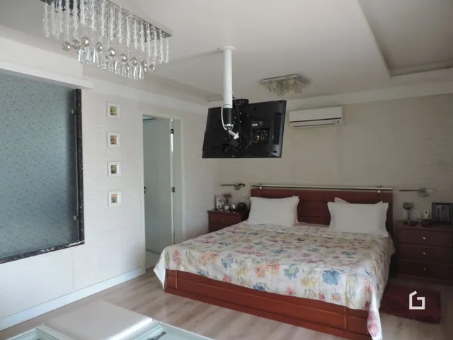 Quarto com cama de madeira e luminária de cristal