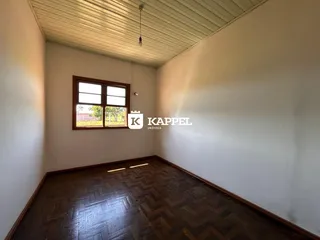 Foto de um ambiente interno com piso de madeira e janela.