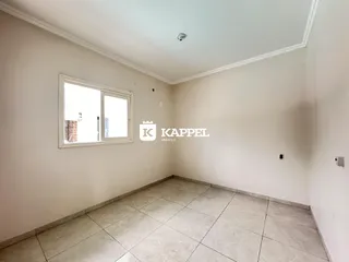 Uma foto de um cômodo interno com paredes brancas e piso de cerâmica.
