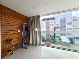 Sala de estar com revestimento de madeira e porta de vidro para a área externa.