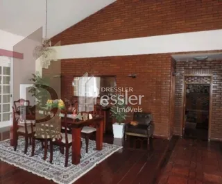 Sala de jantar com paredes de tijolo aparente e piso de madeira.
