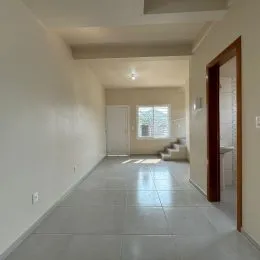 Foto de um corredor interno com paredes brancas e piso claro.
