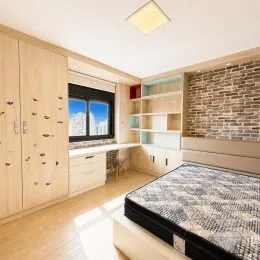 Quarto com cama e parede de tijolos aparentes.