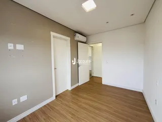 Hall de entrada com piso de madeira clara e paredes cinzas.