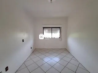 Foto de um cômodo interno com paredes brancas e piso de cerâmica.