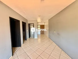 Corredor interno com piso de cerâmica e portas escuras.